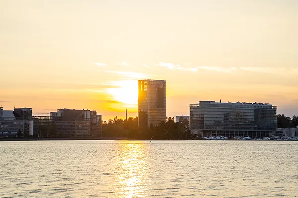 Ryhmä rentoja ihmisiä valoisassa tilassa kuuntelemassa etualalla näkyvän esiintyjän puhetta